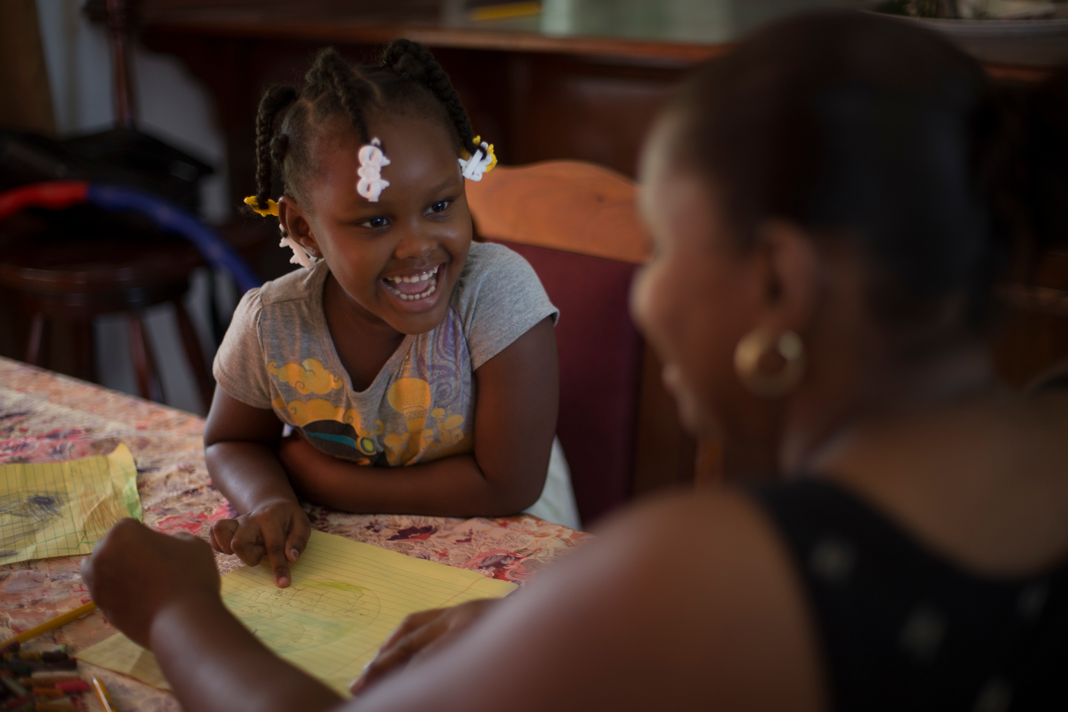 On 20 August 2016 in Belize, 4-year old Zyrah Neal laughs as she and her mother, Sherlette Neal, draw at home at their dining room table, in Belmopan, the capital. Zyrah lives in a middle-class neighbourhood with her mother (who is a government employee), her sister and two brothers. She recently completed preschool and has access to electronics, many toys and books. Ms. Neal, a single-parent, raised six other children before Zyrah was born. She explained the difference she sees in her young daughter’s development as a result of two years of preschool and growing up in a protective and enriching environment: “She’s very advanced, she knows what she wants. I’m raising her in a very different environment to the situations my other children were born into; life was at times chaotic and it had an impact. Zyrah’s a fast learning and loves to get involved in so many activities, it’s hard to keep up sometimes but I manage. My favourite thing to do with her is to go to the park and push her on the swings, and seeing how much she enjoys it.”

In recent years, considerable progress was made in the area of Early Childhood Development. In 2011 only 32 per cent of children between 36 and 59 months of age attended an Early Childhood Education (ECE) programme, but this reached 55 per cent by 2015. Disparities however persist as only one in five of the poorest children attend ECE, and the Cayo district sees the lowest ECE attendance rate (36 per cent).  Further success is contingent upon removing barriers to supply of services, such as sufficient number of qualified professionals and greater integration of the different ECD components. The recent adoption of a national ECD policy demonstrates the Government’s commitment to strengthening ECD services. 

UNICEF and the World Health Organization (WHO), with their national, regional and country partners, promote the use of a range of effective interventions (e.g. Care for Child Development) to help children survive, t